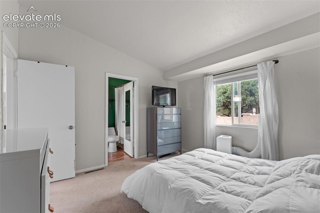 Image 18 of 28: Recessed window with exterior scenery, carpeted flooring, and a hinged door