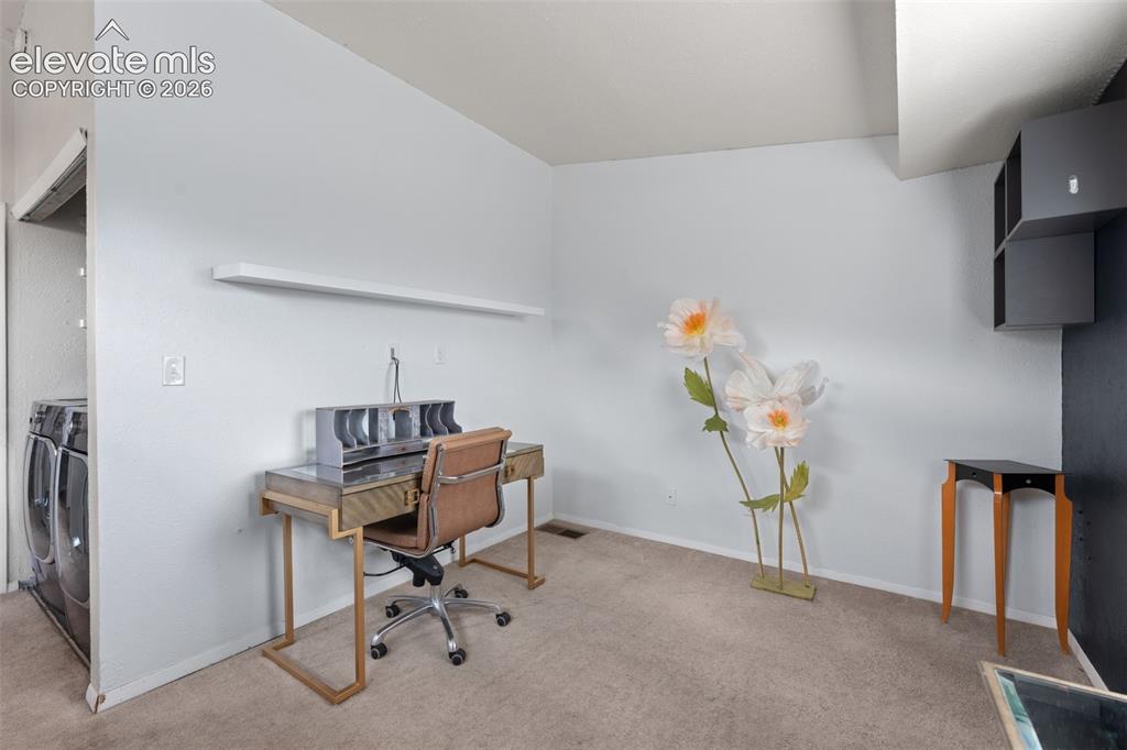 Image 21 of 28: Carpeted room with a wall-mounted shelf and an alcove for appliances