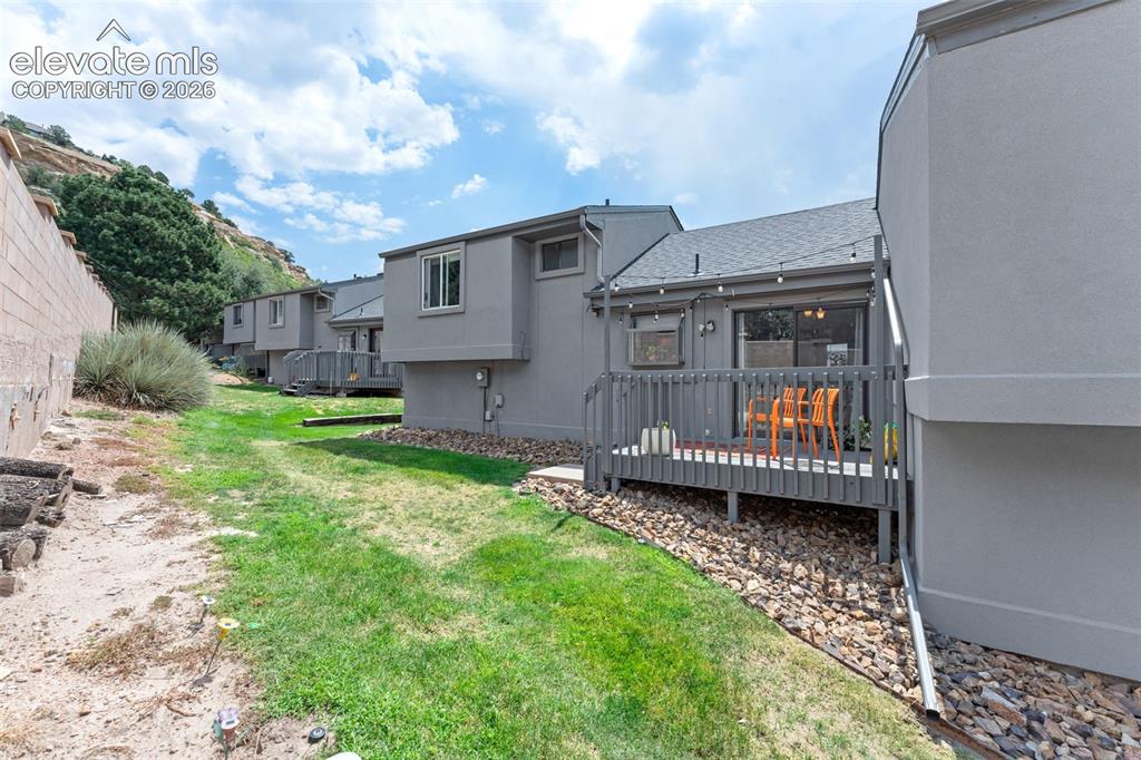 Image 28 of 28: Private exterior deck with a sliding glass door, accompanied by an expansiv