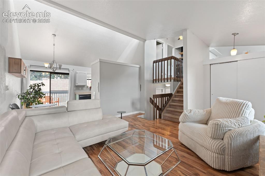 Image 7 of 28: Vaulted ceiling, wood-finish flooring, staircase with wooden railing, built