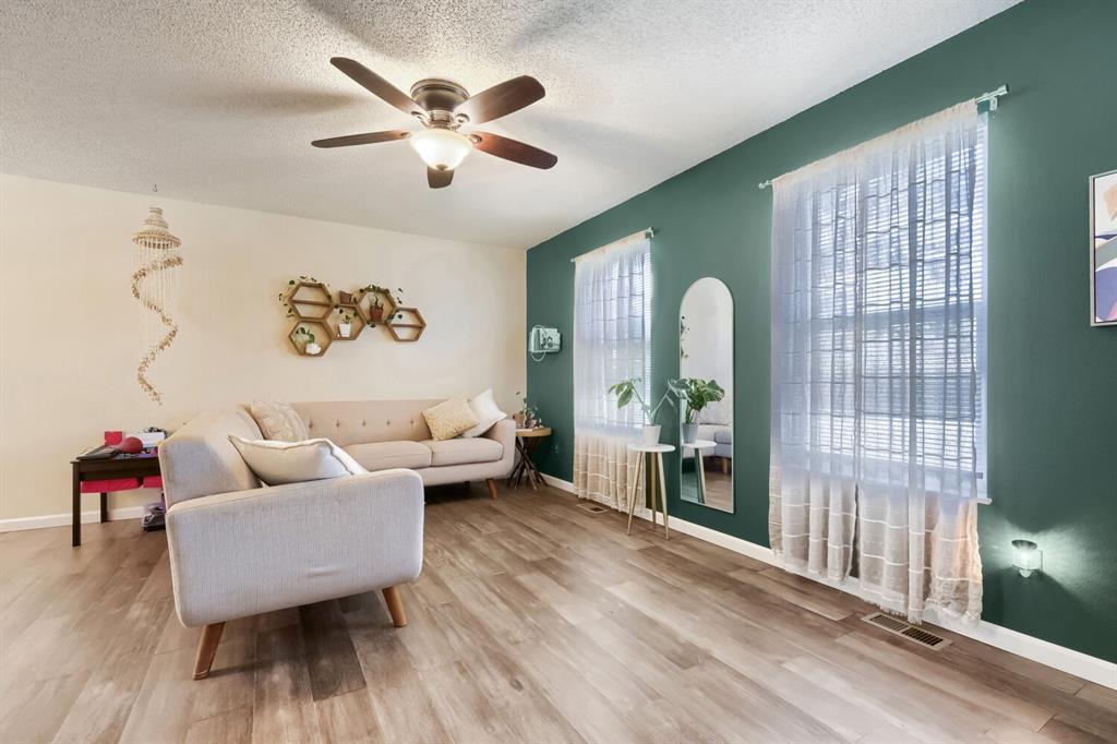 Image 11 of 22: Spacious interior featuring wood-finish flooring, a ceiling fan with integr