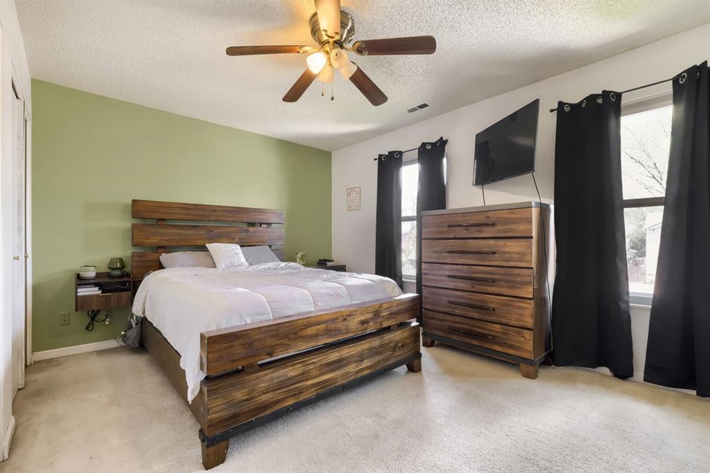 Image 13 of 22: Bedroom featuring carpet flooring, two windows with dark curtains, a ceilin
