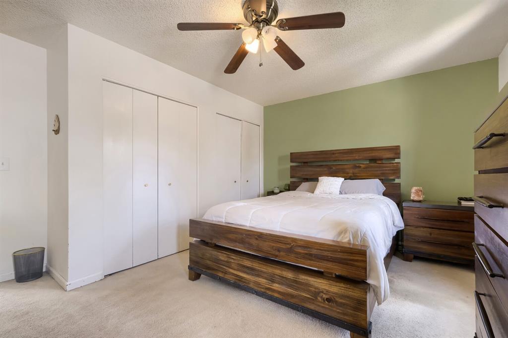 Image 15 of 22: Bedroom featuring light green accent wall, light beige carpeting, a ceiling
