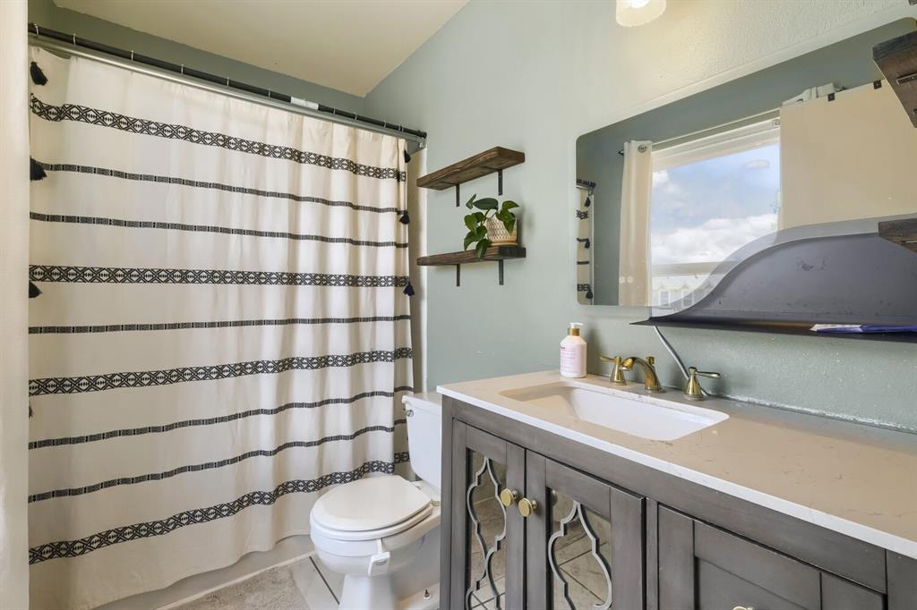 Image 16 of 22: Bathroom vanity with a white countertop and integrated sink