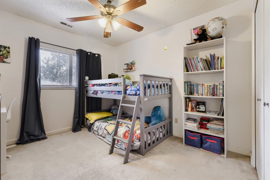 Image 18 of 22: Carpeted room featuring a ceiling fan with integrated lighting, a window wi