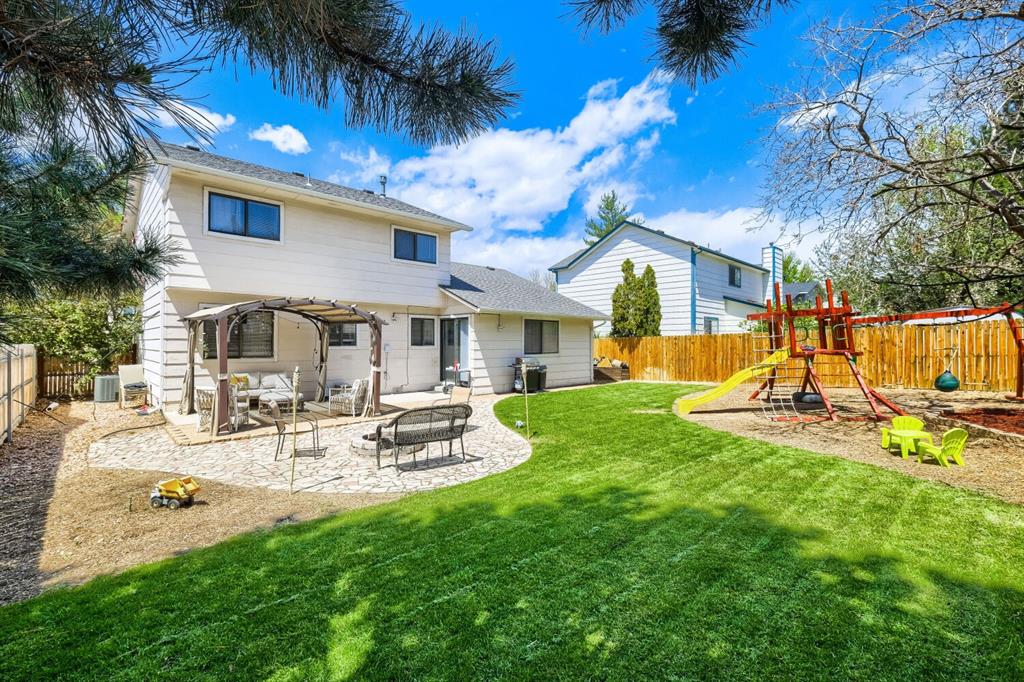 Image 20 of 22: Expansive backyard featuring a stone patio, a dedicated pergola area, a man