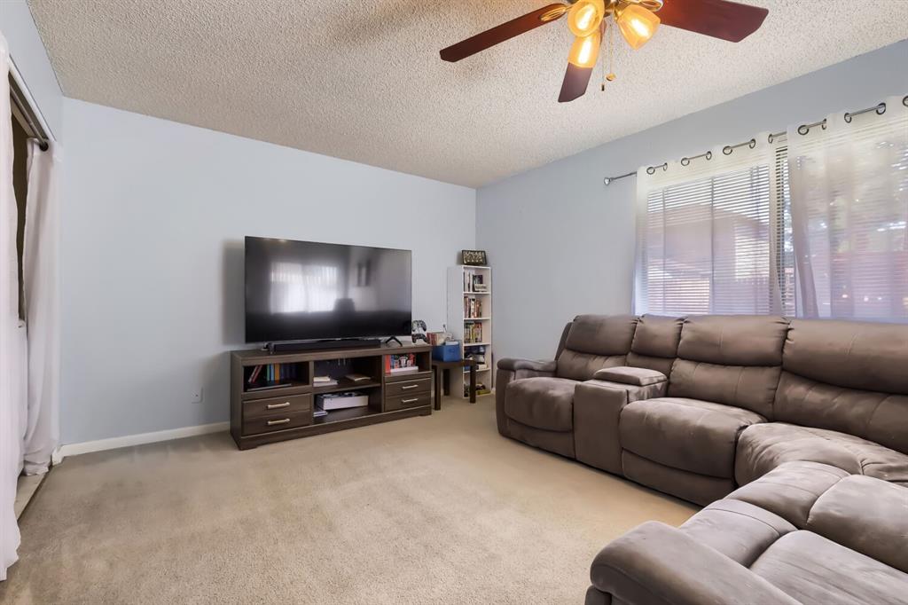 Image 4 of 22: Living area with soft wall color and neutral carpeting