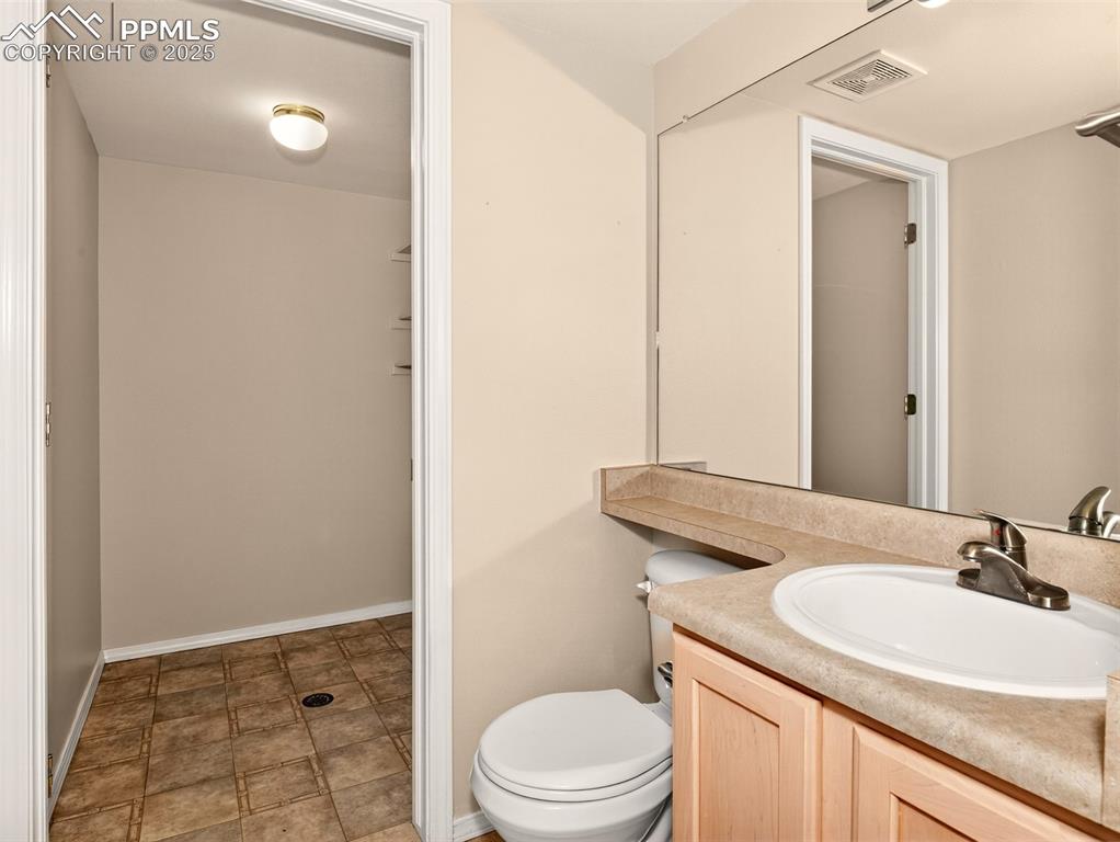 Image 11 of 27: Half bath with vanity and toilet