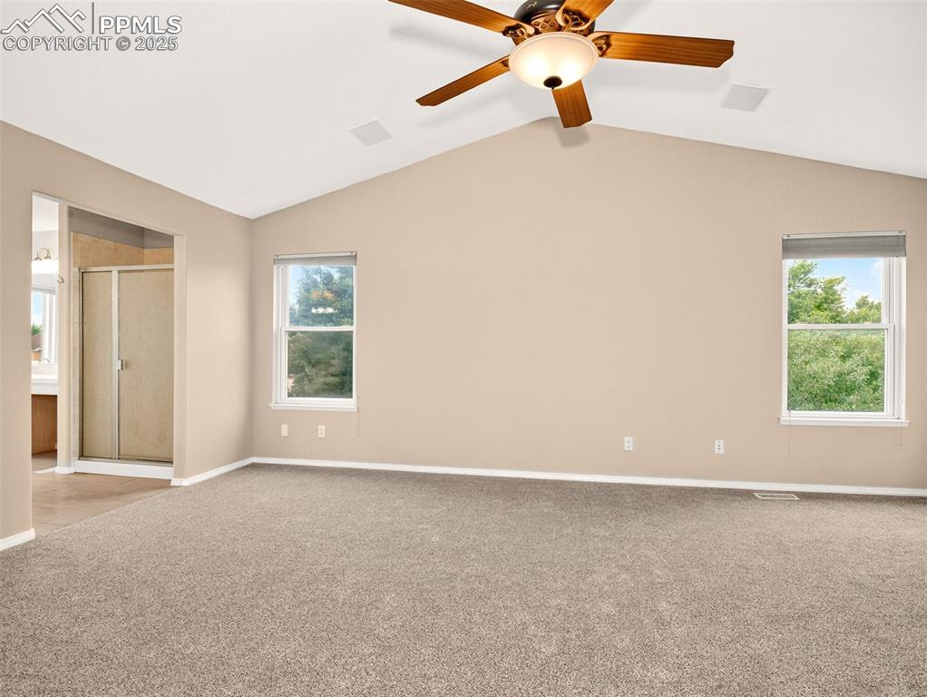 Image 13 of 27: Spare room featuring lofted ceiling, carpet, and a ceiling fan