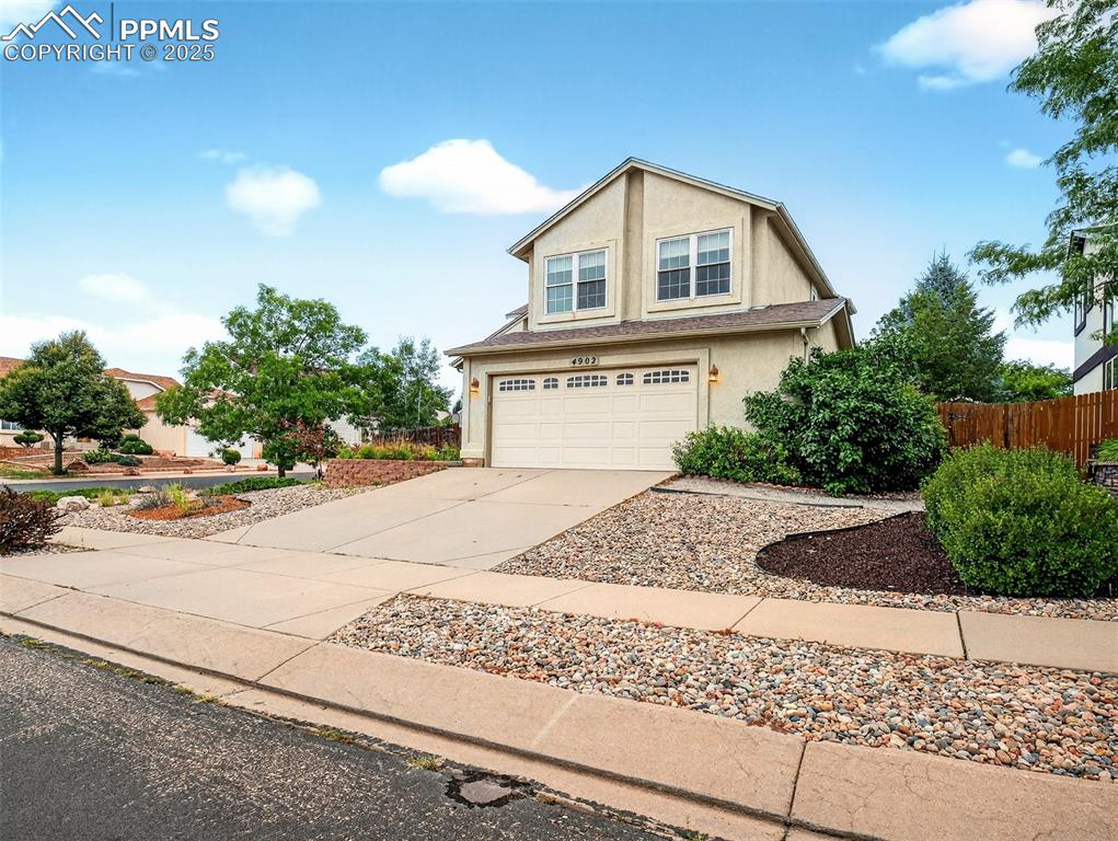Image 2 of 27: View of front of house with concrete driveway, a garage, and stucco siding