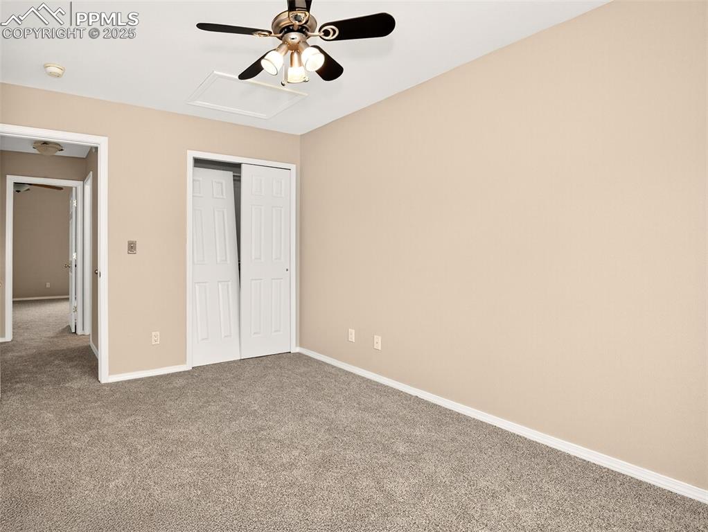 Image 20 of 27: Unfurnished bedroom featuring carpet floors, a closet, attic access, and a 
