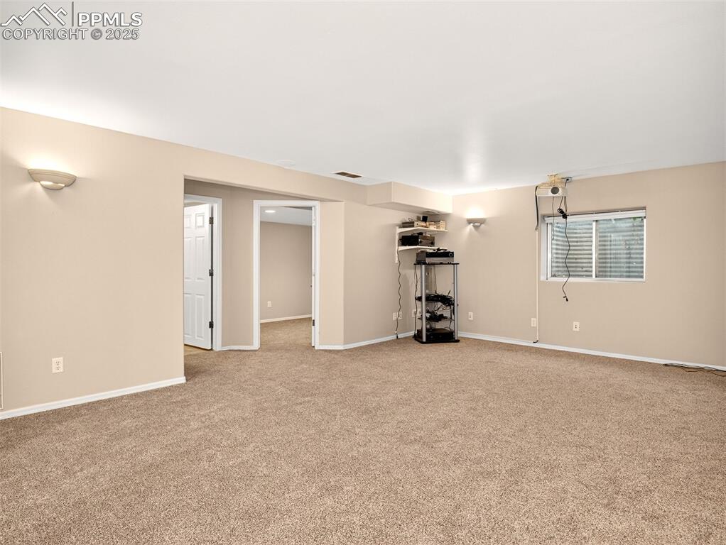 Image 23 of 27: Basement featuring light colored carpet and baseboards