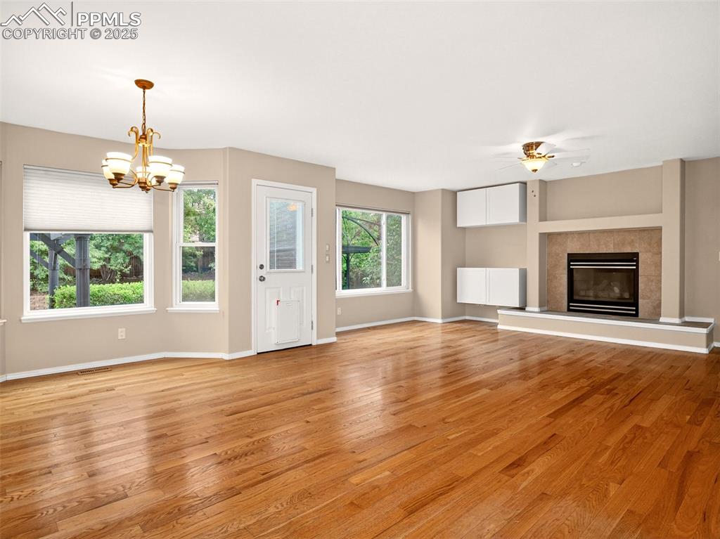 Image 5 of 27: Unfurnished living room featuring a tile fireplace, light wood-type floorin