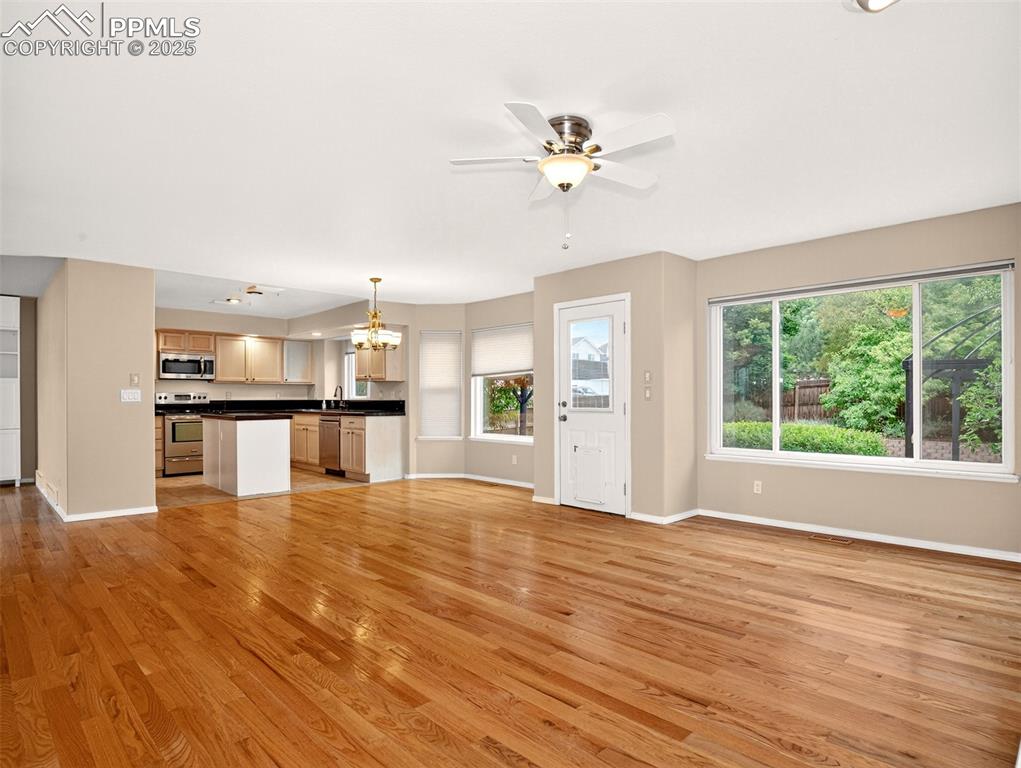 Image 7 of 27: Unfurnished living room featuring light wood finished floors, a chandelier,