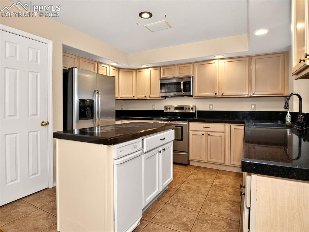 Image 8 of 27: Kitchen featuring light tile patterned flooring, appliances with stainless 