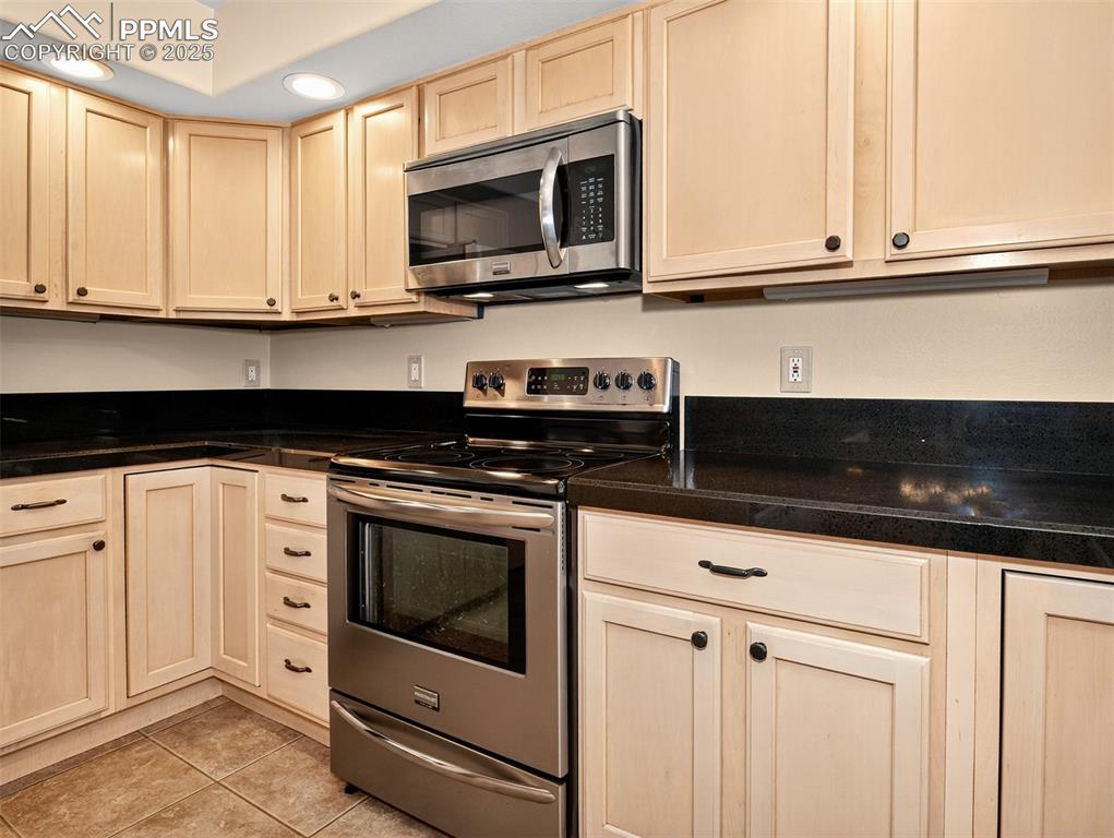 Image 9 of 27: Kitchen featuring appliances with stainless steel finishes, light tile patt