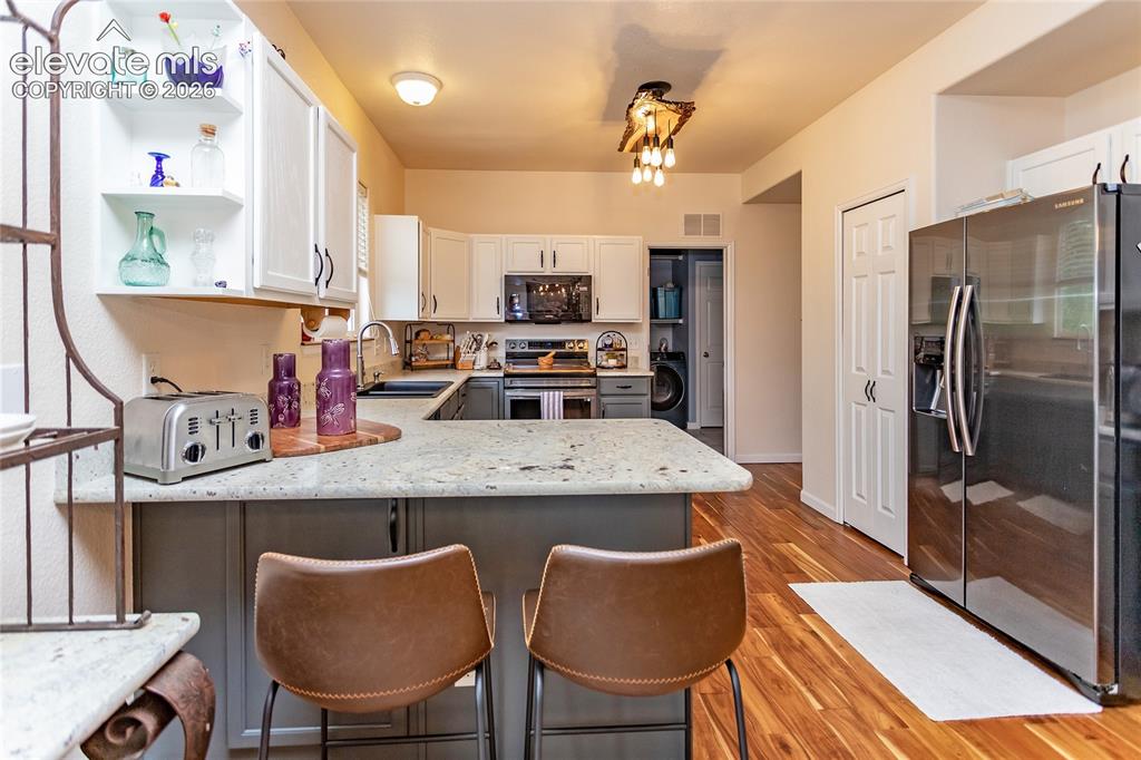 Image 13 of 44: A raised breakfast bar peninsula offers the perfect spot for casual dining,