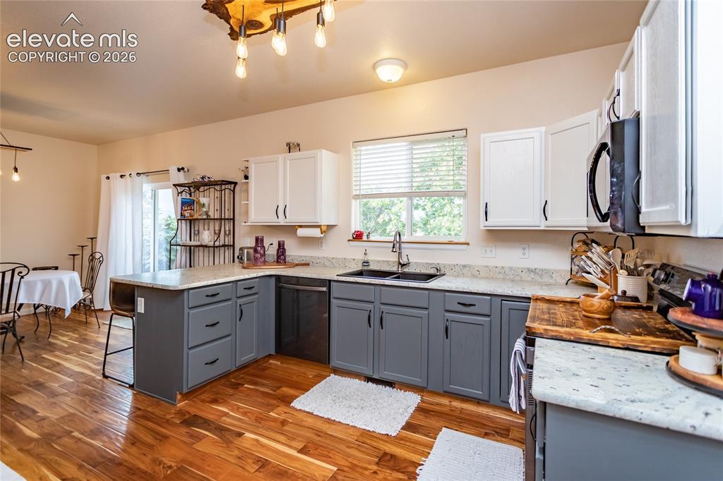 Image 14 of 44: The fully remodeled kitchen boasts custom cabinetry, matching warm-wood lig