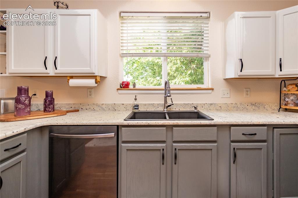 Image 16 of 44: The deep double-basin sink features a modern, tall pull-down faucet and sit