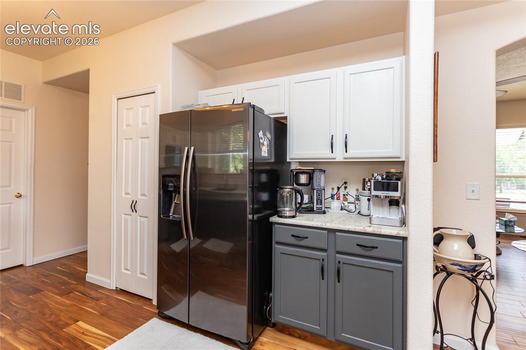 Image 17 of 44: A custom coffee and beverage bar provides extra leathered granite counter s