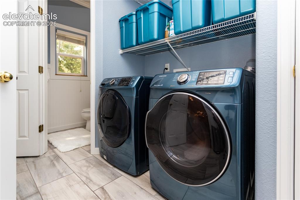 Image 19 of 44: This highly practical mudroom and laundry center includes high-end, front-l