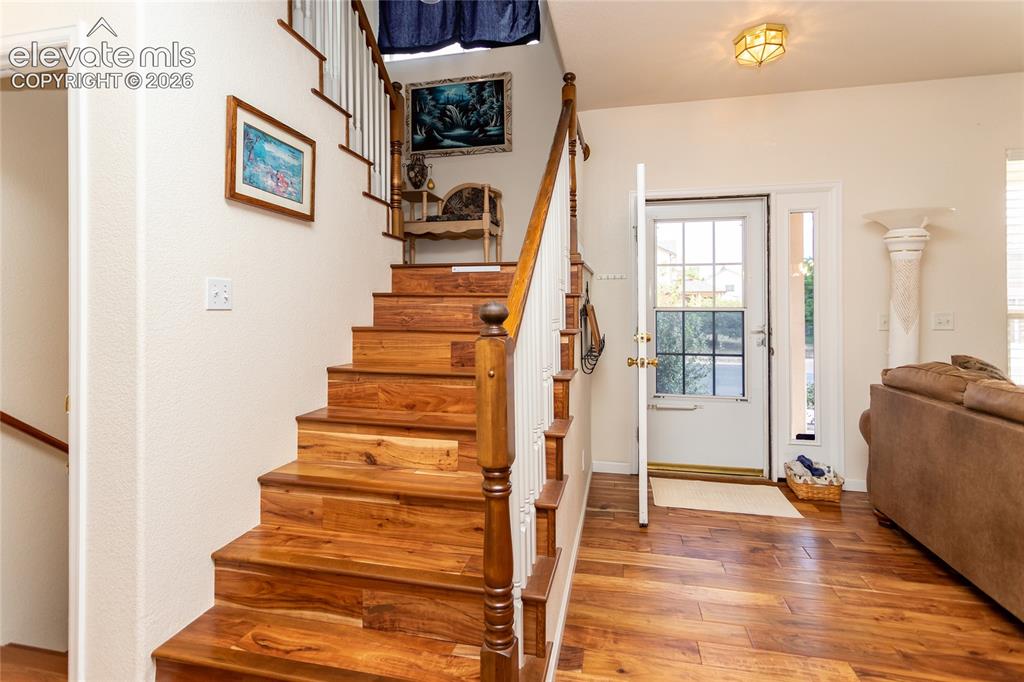 Image 22 of 44: The central wooden staircase serves as a handsome design anchor, bridging t