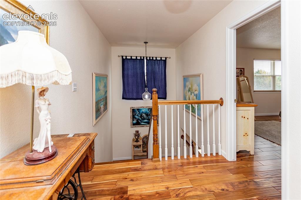 Image 23 of 44: Flawless Acacia hardwood flooring continues across the entire upper landing