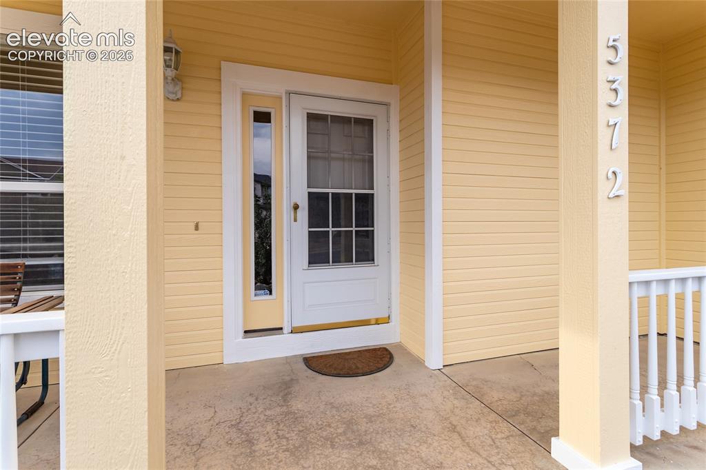 Image 3 of 44: The concrete covered entryway offers low-maintenance protection from the el