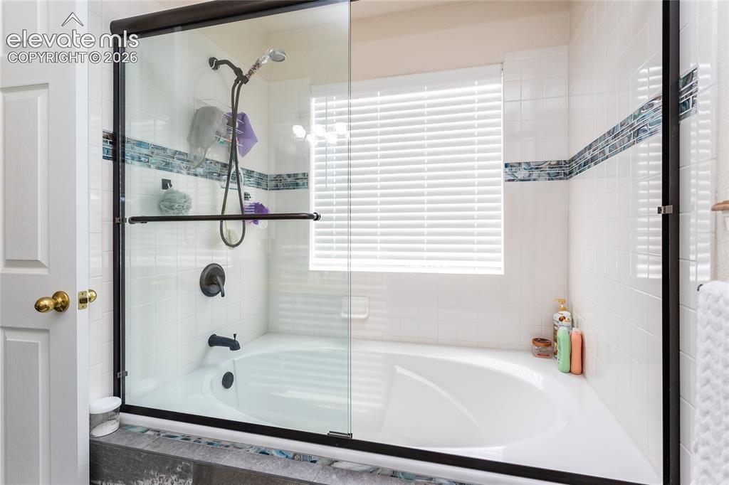 Image 31 of 44: Sleek black plumbing fixtures and pristine white tiling blend contemporary 