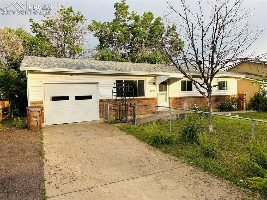 Image 2 of 17: Single story home with brick siding, a fenced front yard, driveway, and a g