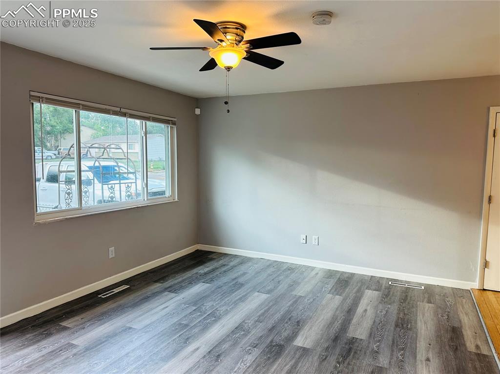 Image 6 of 17: Empty room with a smoke detector, wood finished floors, and a ceiling fan