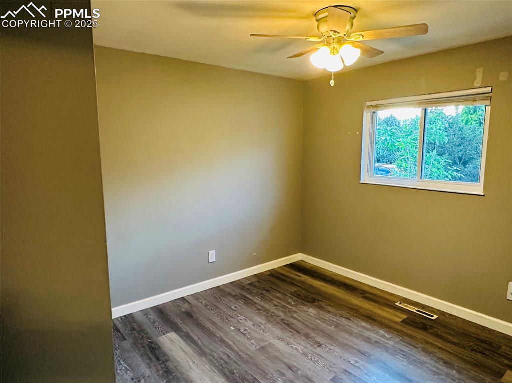 Image 9 of 17: Spare room with ceiling fan and dark wood-type flooring