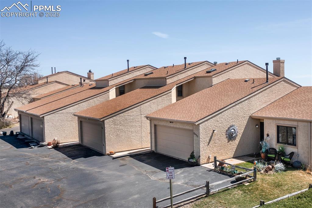 Image 2 of 44: Aerial View of front of house with roof with shingles, stucco siding, and a