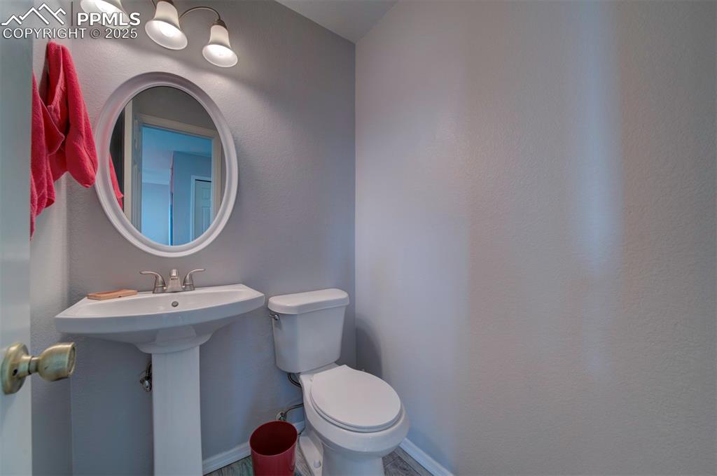 Image 26 of 44: 1/2 Bathroom featuring toilet and a textured wall on main level