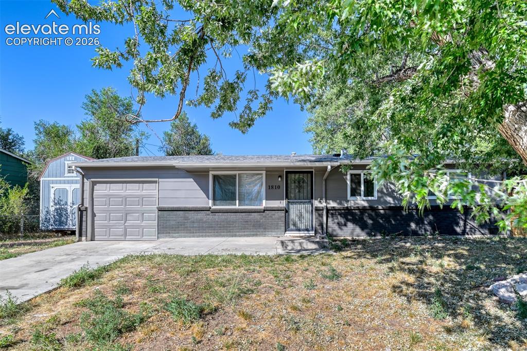 Image 1 of 35: Ranch-style exterior featuring gray siding, a dark brick accent, and a sing