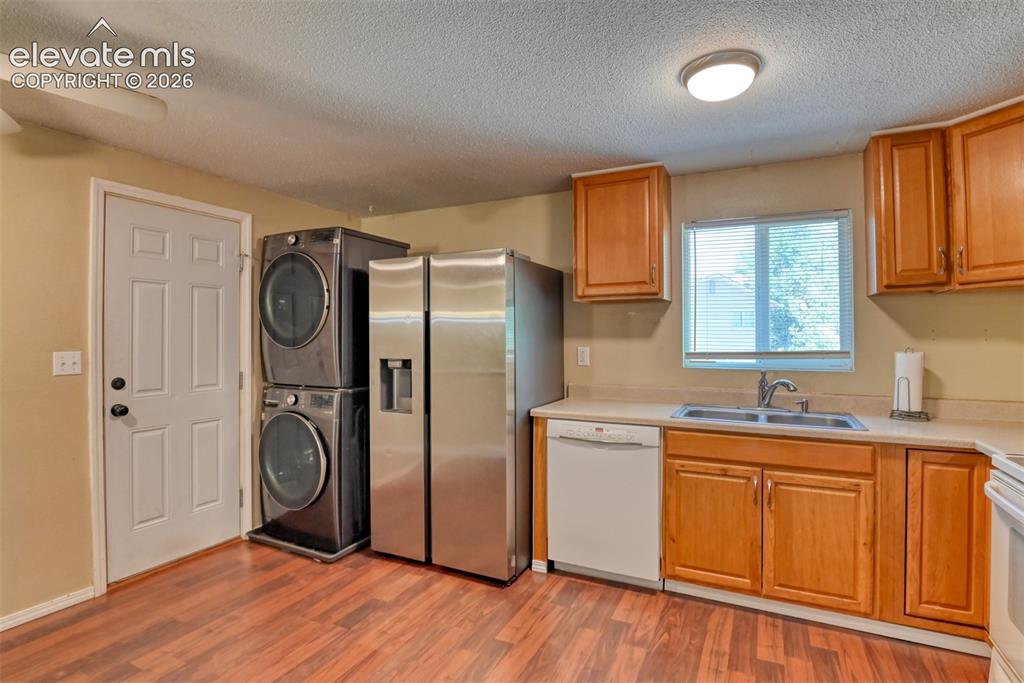 Image 13 of 35: Kitchen area with wood-finish flooring, light-toned cabinetry, and a double
