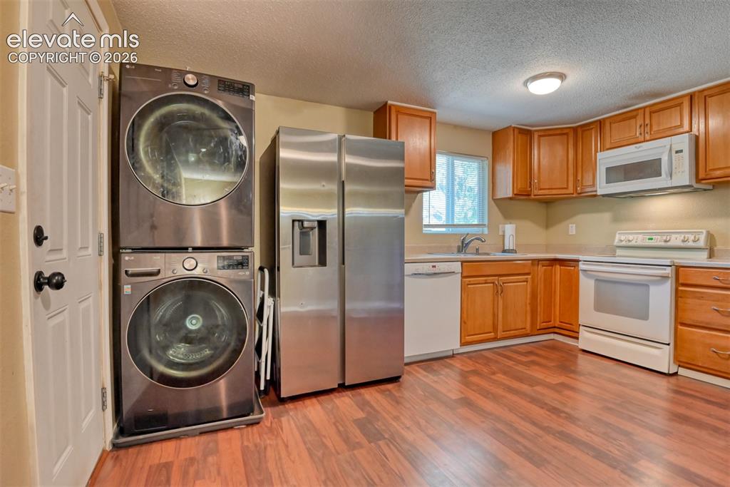 Image 14 of 35: Kitchen featuring wood-finish flooring, wood cabinetry, stainless steel ref