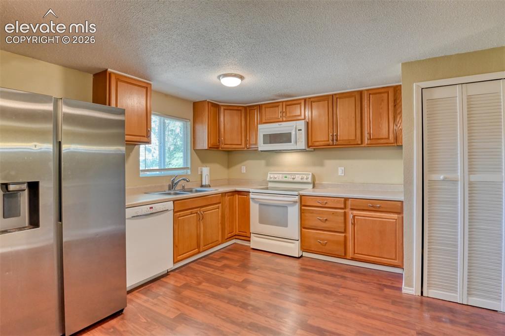 Image 15 of 35: Kitchen featuring wood-finish flooring, a full suite of appliances includin