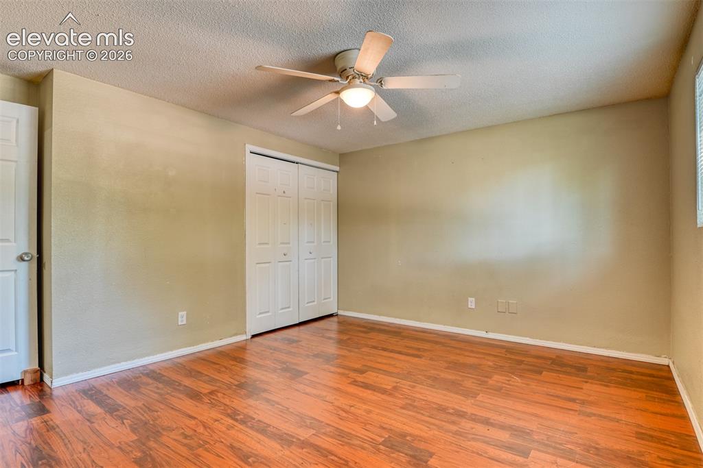 Image 18 of 35: Spacious room featuring wood-finish flooring, a ceiling fan with integrated