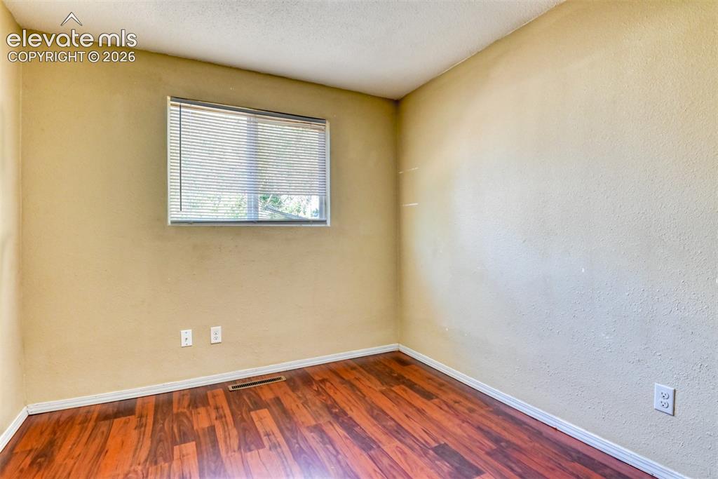 Image 19 of 35: Room featuring wood-finish flooring, a window with horizontal blinds, textu
