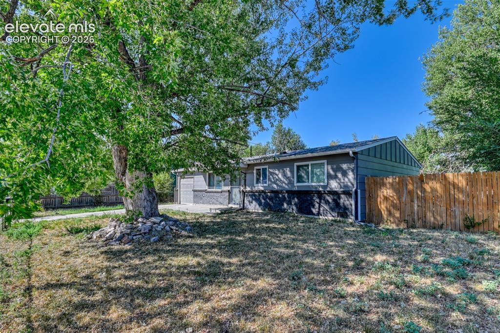 Image 2 of 35: Ranch-style exterior featuring gray siding, a dark foundation, and white-fr