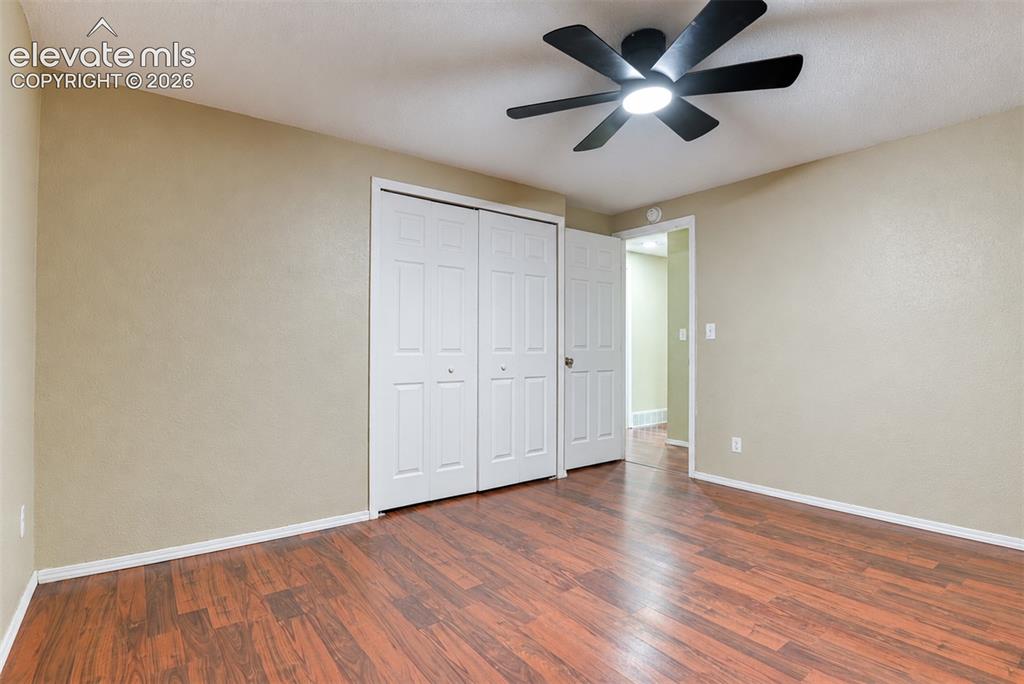 Image 22 of 35: Room featuring wood-finish flooring, neutral wall paint, white baseboards, 