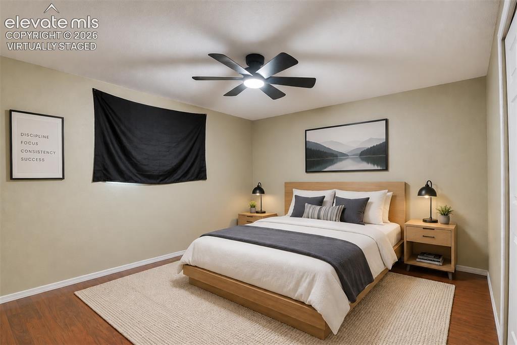 Image 29 of 35: Virtually staged Spacious bedroom featuring wood-finish flooring, a contemp