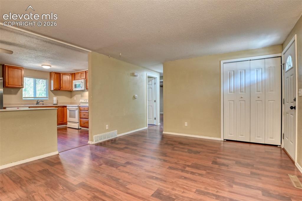 Image 8 of 35: Open concept living area featuring wood-finish flooring