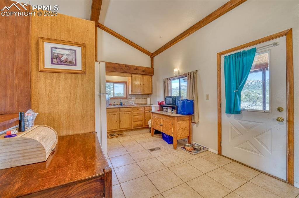 Image 11 of 45: Kitchen featuring light tile patterned floors, light countertops, decorativ