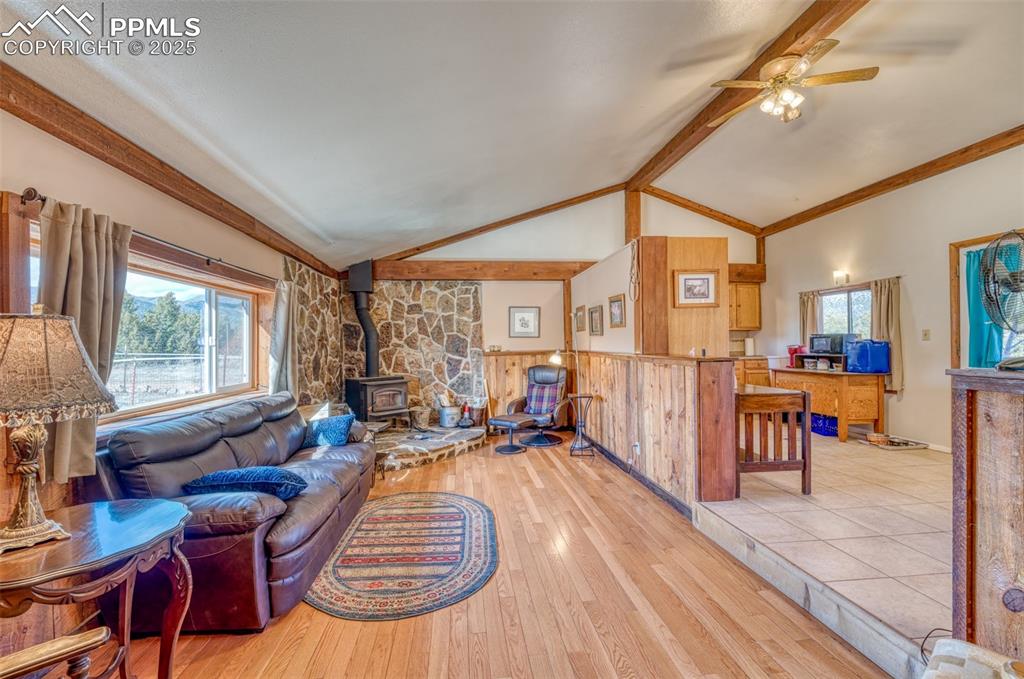Image 14 of 45: Living area featuring a wood stove, a ceiling fan, and light wood finished