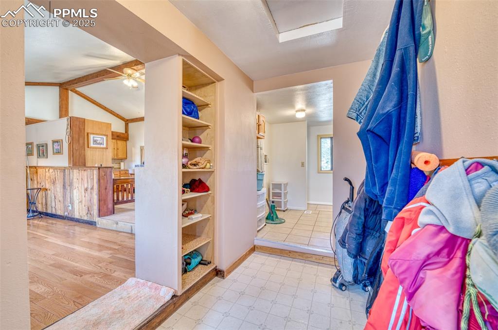 Image 16 of 45: Foyer entrance with lofted ceiling, a ceiling fan, and baseboards