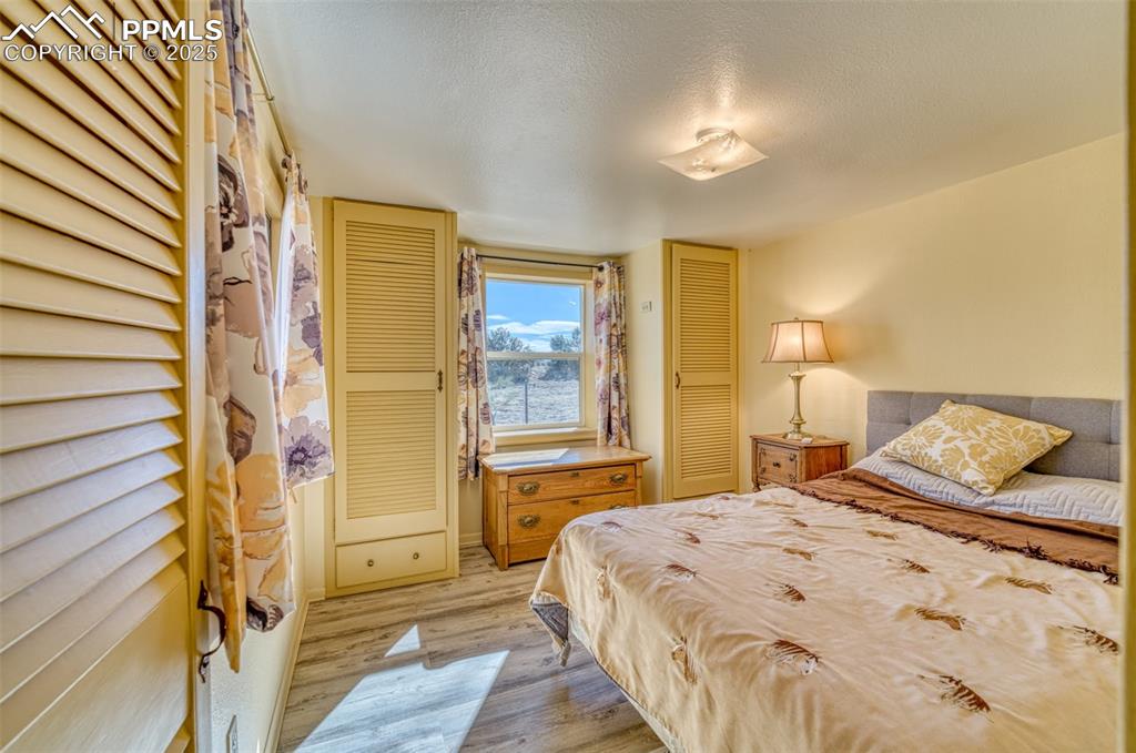Image 21 of 45: Bedroom featuring light wood-style flooring and a textured ceiling