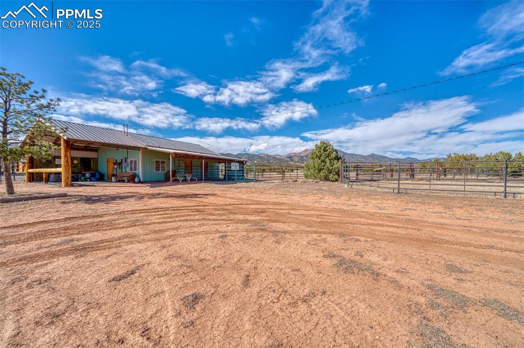 Image 28 of 45: Back of house with an exterior structure, metal roof, a mountain view, an o