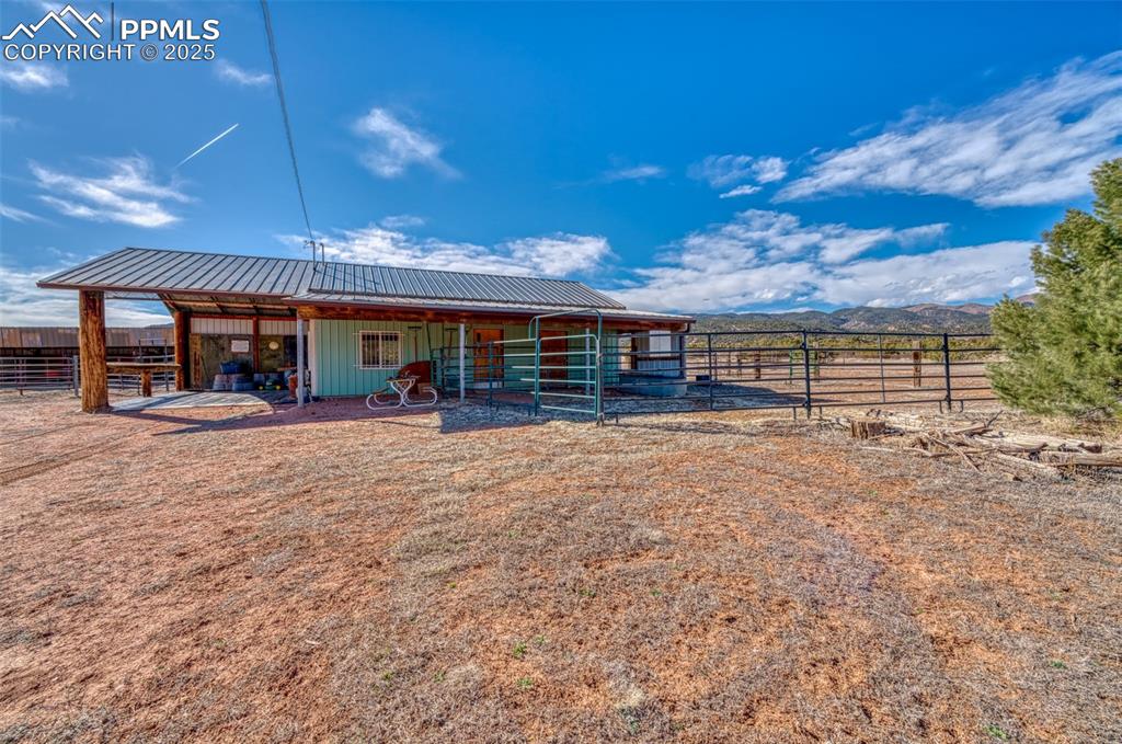 Image 39 of 45: Rear view of house with an exterior structure, an outbuilding, metal roof,